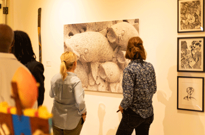 Two museum guests viewing a wall image containing fish.